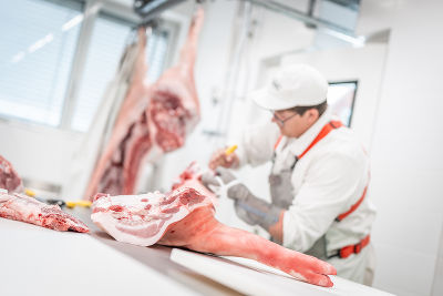 Mitarbeiter beim Aufarbeiten von Fleisch Mitarbeiter beim Aufarbeiten von Fleisch
